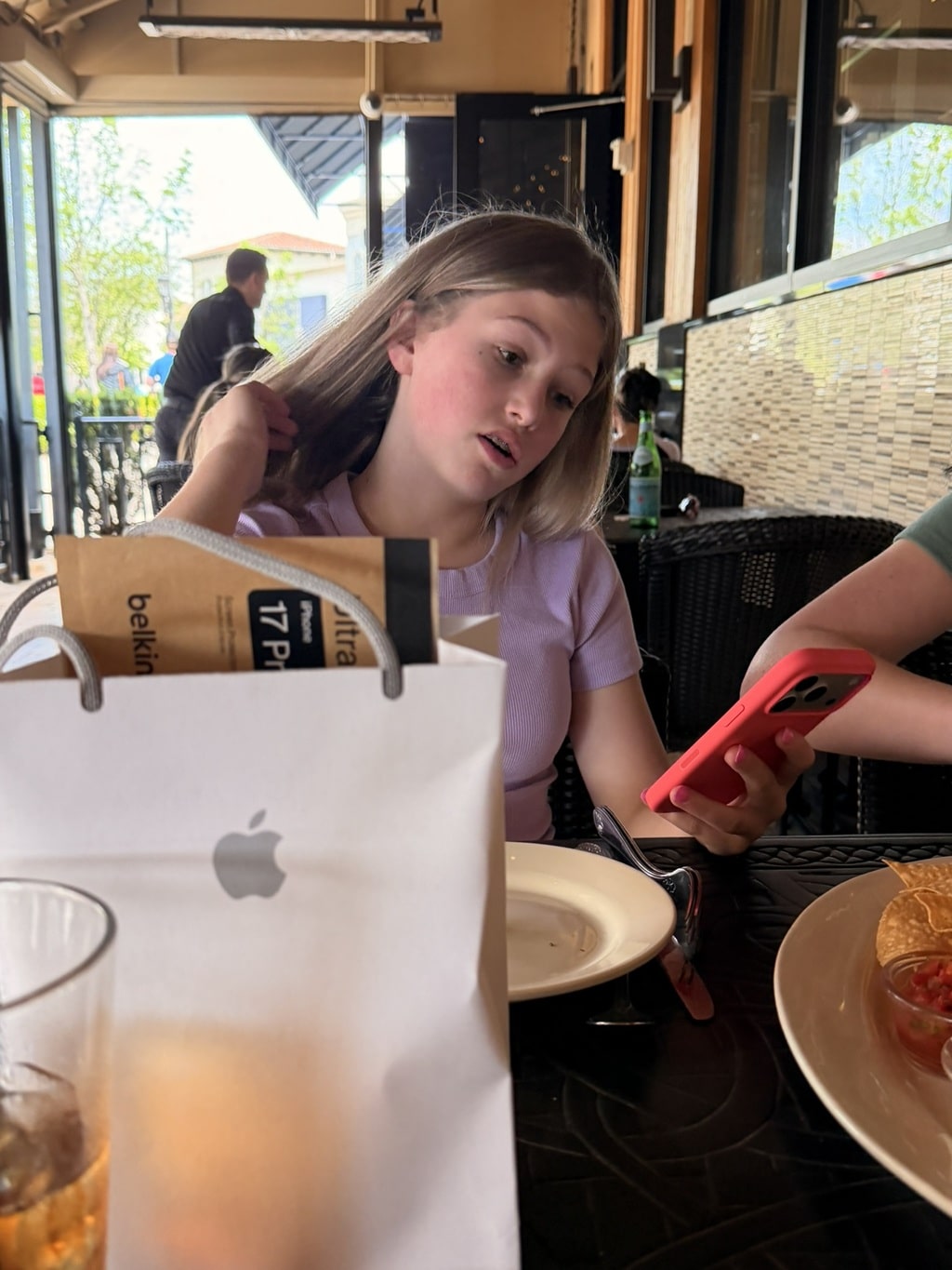 Kynzley holding her new iPhone 17 Pro at lunch after visiting the Apple Store